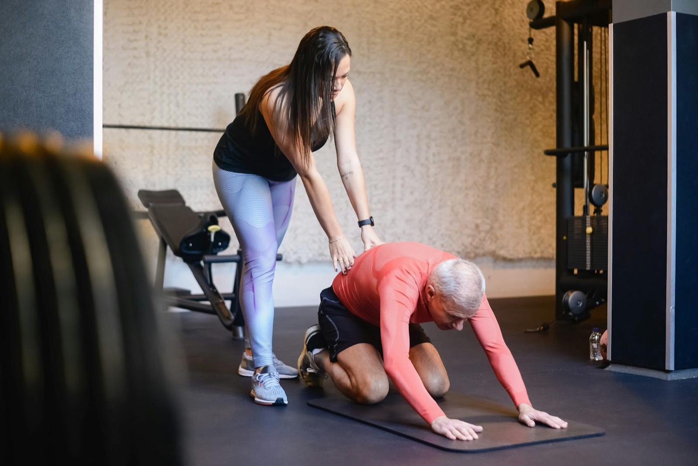 Trainer assisting a client through a floor stretch