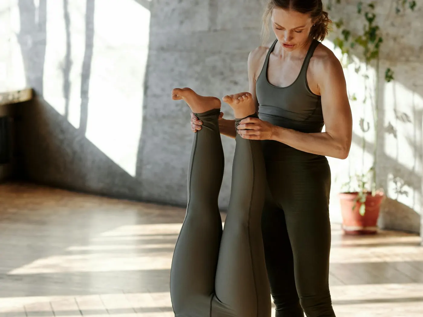 Trainer supporting a client through a mobility stretch